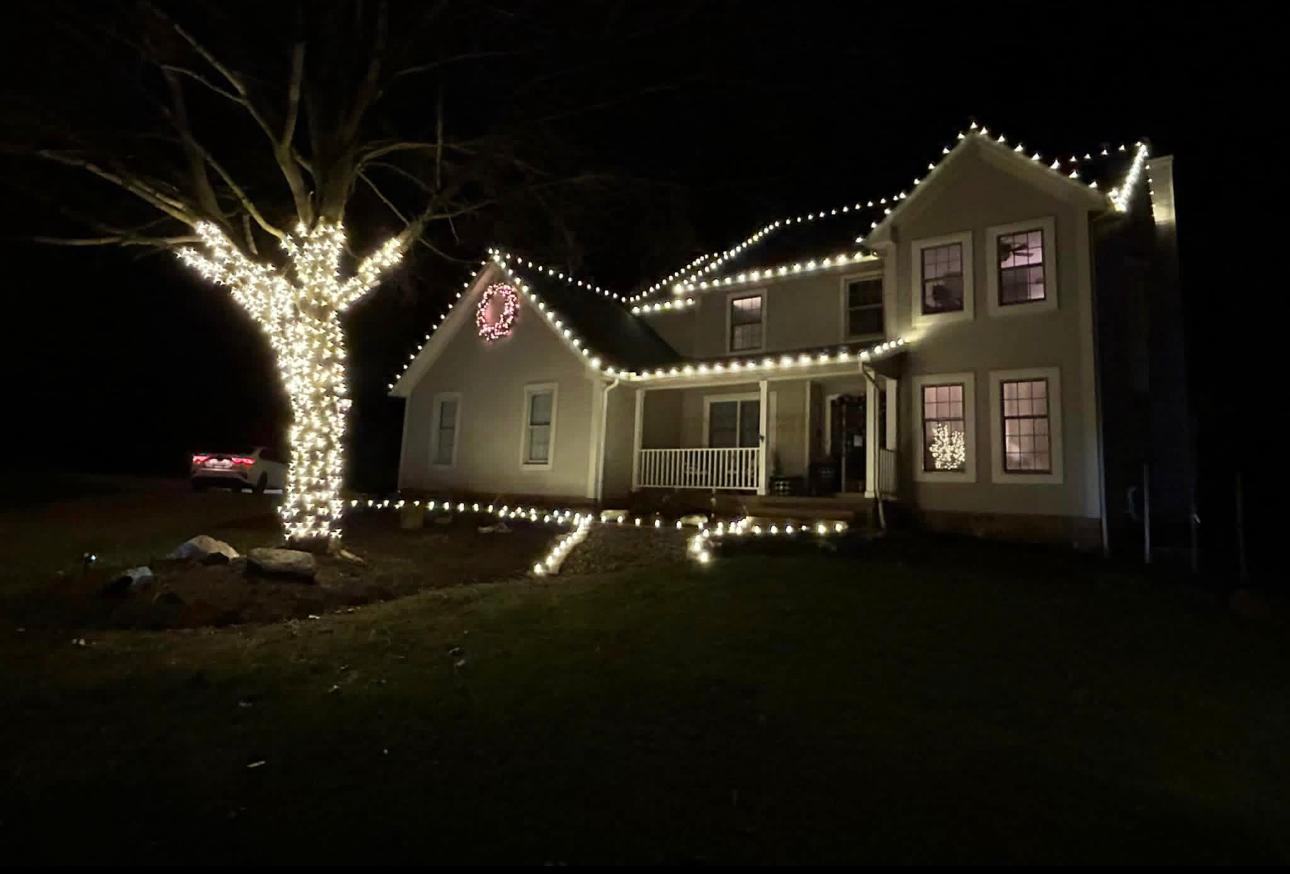 Warm white roofline with a fully wrapped front-yard oak